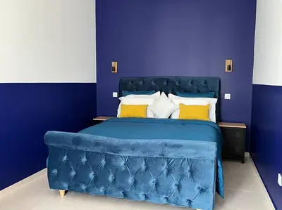 a bedroom with a blue bed with yellow pillows at maisonnette avec piscine la picholine in Châteaurenard