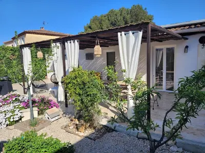 a house with white curtains in the yard at maisonnette avec piscine la picholine in Châteaurenard