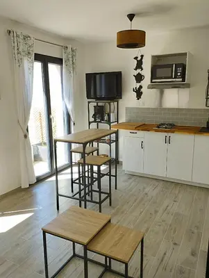 a kitchen with two tables and a counter with a microwave at Studio de charme en Provence in Caromb