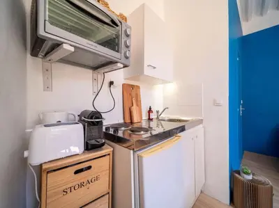 a small kitchen with a microwave above a stove at Studio tout équipé au coeur de Aix en Provence in Aix-en-Provence