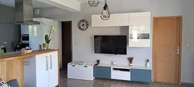 a kitchen with white cabinets and a tv on the wall at Maison avec piscine en Provence in Saint-Cannat