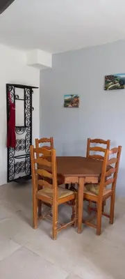a wooden table and two chairs sitting next to a wall at Campagne Carbonel in Aix-en-Provence