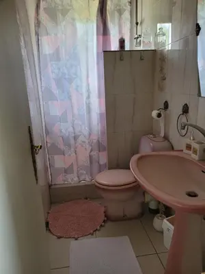 a bathroom with a pink toilet and a sink at Location saisonnière villa Lauris in Lauris