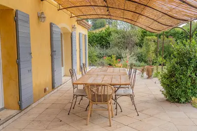 a wooden table and chairs on a patio at Maison à 2 pas du Village D'ansouis à 30 Minutes D'aix-en-provence in Ansouis
