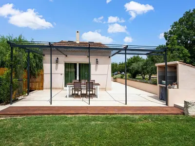 a patio with a table and chairs on a deck at Holiday Home in Vaucluse near Mont Ventoux in Pernes-les-Fontaines