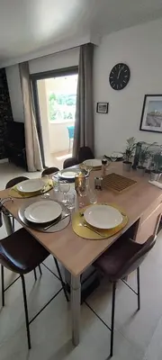 a large wooden table with chairs and a clock on the wall at Gîte Aux Bons Voisins in Gordes