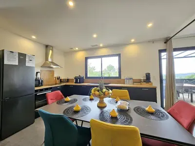 a kitchen with a table and chairs and a kitchen with a refrigerator at Villa lavandin in Apt