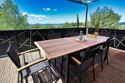 a wooden table and chairs on a deck at Villa lavandin in Apt