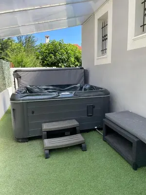 a room with a bed and a bench on the grass at VILLA NOUNOU in Le Thor