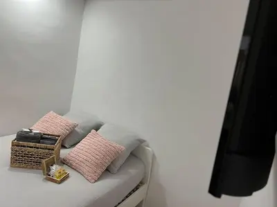 a bed with two pink pillows and a basket on it at Chambre Mignet in Aix-en-Provence