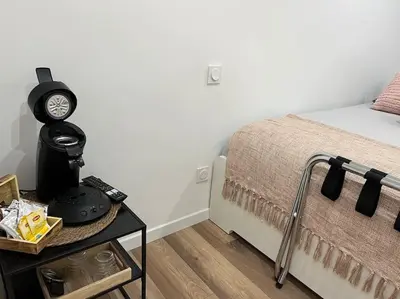 a bedroom with a bed and a clock on a table at Chambre Mignet in Aix-en-Provence
