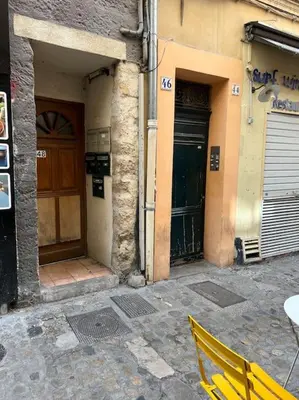 a yellow chair sitting in front of a building at Chambre Mignet in Aix-en-Provence