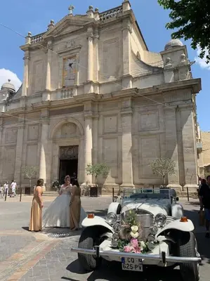 a bride and groom and an old car in front of a building at La terrasse du pont jullian charme et calme dans le cœur historique in LʼIsle-sur-la-Sorgue