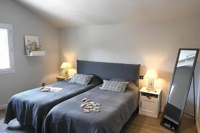 a bedroom with a bed with a blue blanket and a mirror at La Villa Moderna in Robion en Luberon