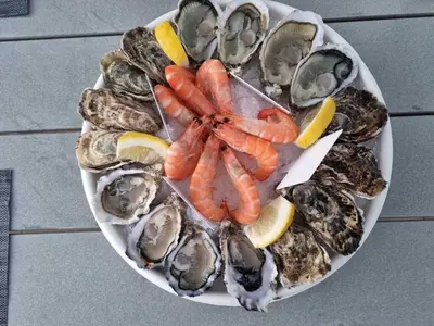 a plate of oysters and vegetables on a table at La Villa Moderna in Robion en Luberon