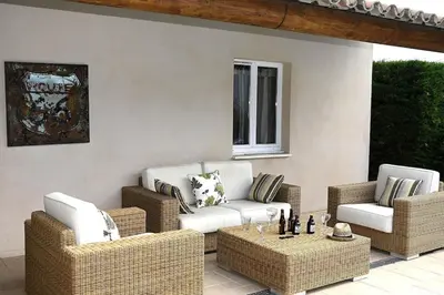 a patio with two chairs and a couch and a table at La Villa Moderna in Robion en Luberon