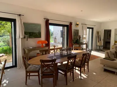 a dining room with a wooden table and chairs at Contemporary house 5mn away from Aix in the countryside in Aix-en-Provence