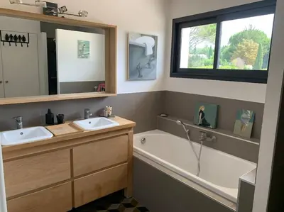 a bathroom with two sinks and a bath tub and a window at Contemporary house 5mn away from Aix in the countryside in Aix-en-Provence