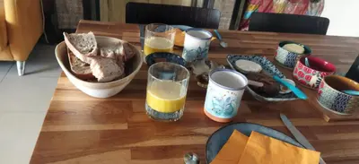 a wooden table topped with plates and glasses of orange juice at Aude en Provence in Meyrargues