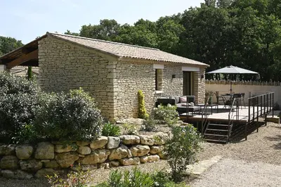 a brick house with a patio and a stone wall at Les Agapanthes de Gordes in Gordes