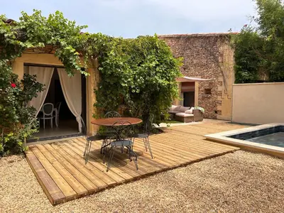 a wooden deck with a table and chairs on it at Maison à Gordes dans le Lubéron in Gordes