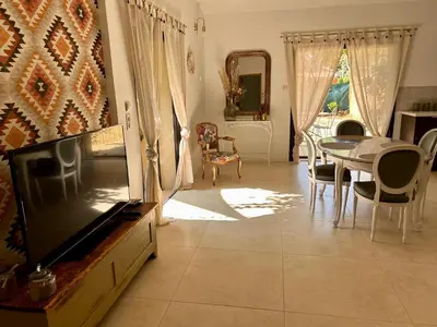 a living room with a tv and a table and chairs at Maison à Gordes dans le Lubéron in Gordes