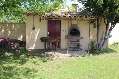 a small house with an oven in a yard at Mas La Gentille ,,, à la campagne , beautiful outdoor , swimming pool , pool house , Nice green Garden , BBQ ,,, only for you , pour passer un séjour inoubliable in Pernes-les-Fontaines