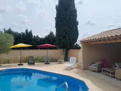 a swimming pool with chairs and umbrellas on a patio at Mas La Gentille ,,, à la campagne , beautiful outdoor , swimming pool , pool house , Nice green Garden , BBQ ,,, only for you , pour passer un séjour inoubliable in Pernes-les-Fontaines