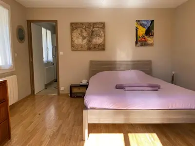 a bedroom with a large bed with pink sheets at Casa Mia, chambre privée en Provence in LʼIsle-sur-la-Sorgue