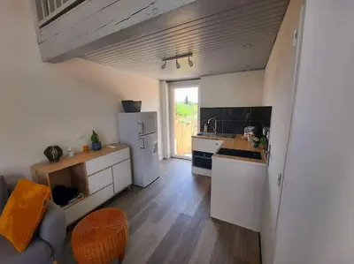a kitchen with a refrigerator and a counter top at adorable guest house avec jardin et parking privatif in Aix-en-Provence