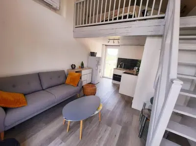 a living room with a couch and a table at adorable guest house avec jardin et parking privatif in Aix-en-Provence