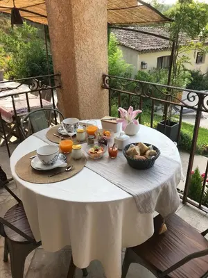 a white table with food on it on a balcony at Chambres d'hôtes La Manola in Rognes