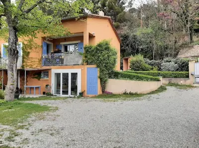 a house with a blue door and a balcony at T.Belle Vue Panoramique au coeur du Luberon 40m2 + pergola . jardin. P in Apt