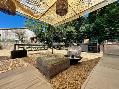 a patio with a table and chairs under a pergola at Le Cabanon de Léandre in Meyrargues