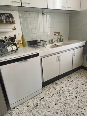 a kitchen with white cabinets and a sink at A l'ombre de l'olivier in Orgon