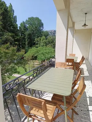 a table and chairs on the balcony of a house at A l'ombre de l'olivier in Orgon
