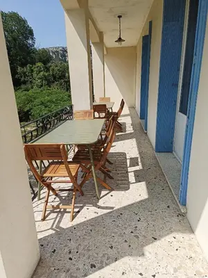 a table and chairs on the balcony of a house at A l'ombre de l'olivier in Orgon