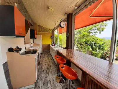 a kitchen with a bar and a counter with a window at Villa charmante à Mérindol avec piscine privée in Mérindol
