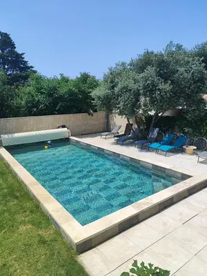a swimming pool in a yard with chairs and trees at Coeur de Provences in Saint-Didier