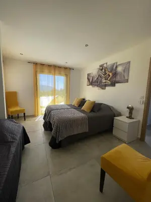 a bedroom with a bed and a chair and a window at Les pins du Luberon in Coustellet