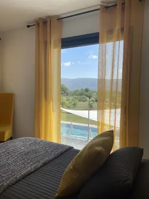 a bedroom with a window with a view of a pool at Les pins du Luberon in Coustellet