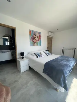 a bedroom with a bed and a painting on the wall at Les pins du Luberon in Coustellet