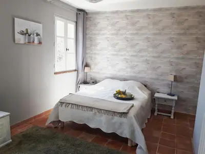 a bedroom with a bed and a brick wall at La bastide de Cocagne in Rognes