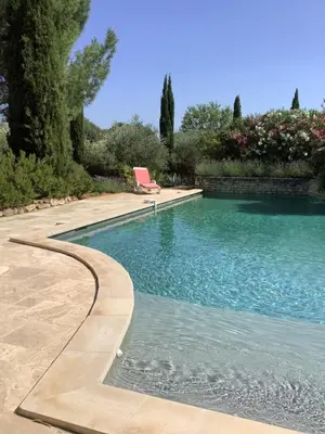 a swimming pool with a chair in a yard at La bastide de Cocagne in Rognes