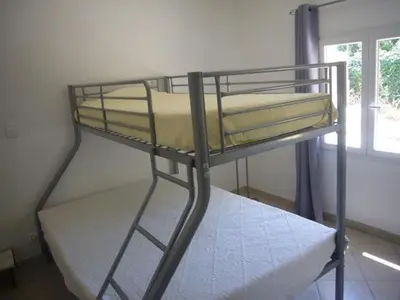 a bunk bed in a room with a window at Goult (LUBERON) A 150 m de la piste cyclable Maison en campagne avec Gde piscine in Goult