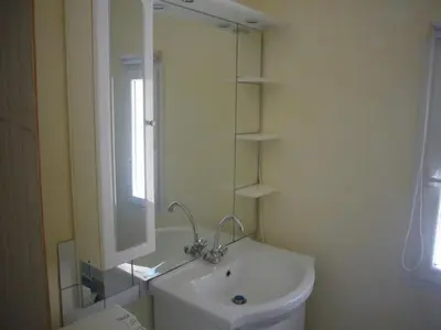 a white bathroom with a sink and a mirror at Goult (LUBERON) A 150 m de la piste cyclable Maison en campagne avec Gde piscine in Goult