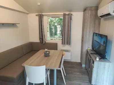 a flat screen tv sitting on a entertainment center at Mobilhome 228 proche du Lac , Tv , clim ect Camping in La Roque-dʼAnthéron