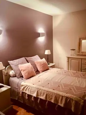 a bedroom with a large bed with pink pillows at villa entre st rémy de provence et avignon in Noves