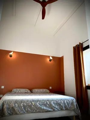 a bedroom with a bed with an orange wall at Viva la vida in Entraigues-sur-la-Sorgue