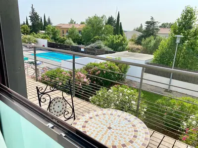 a balcony with a table and a swimming pool at Ma place au sud 1.08 in Éguilles